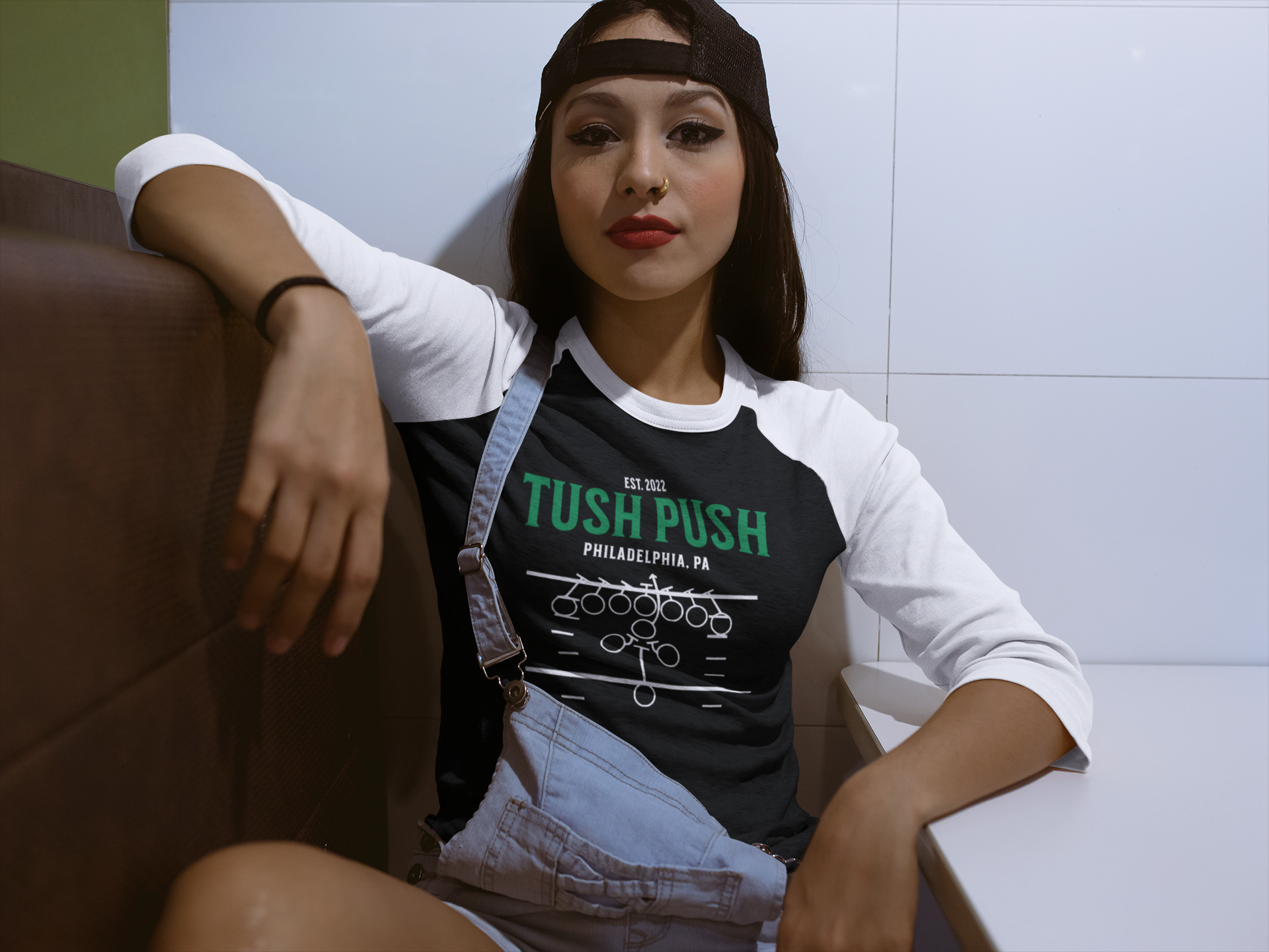 Woman wearing a black 'Tush Push' shirt sitting on a couch.