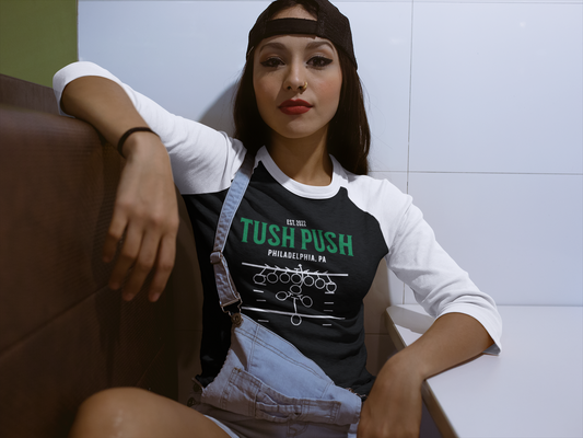 Woman wearing a black 'Tush Push' shirt sitting on a couch.